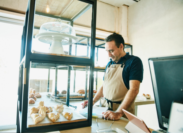 bakery owner standing at the counter reviewing a lease document